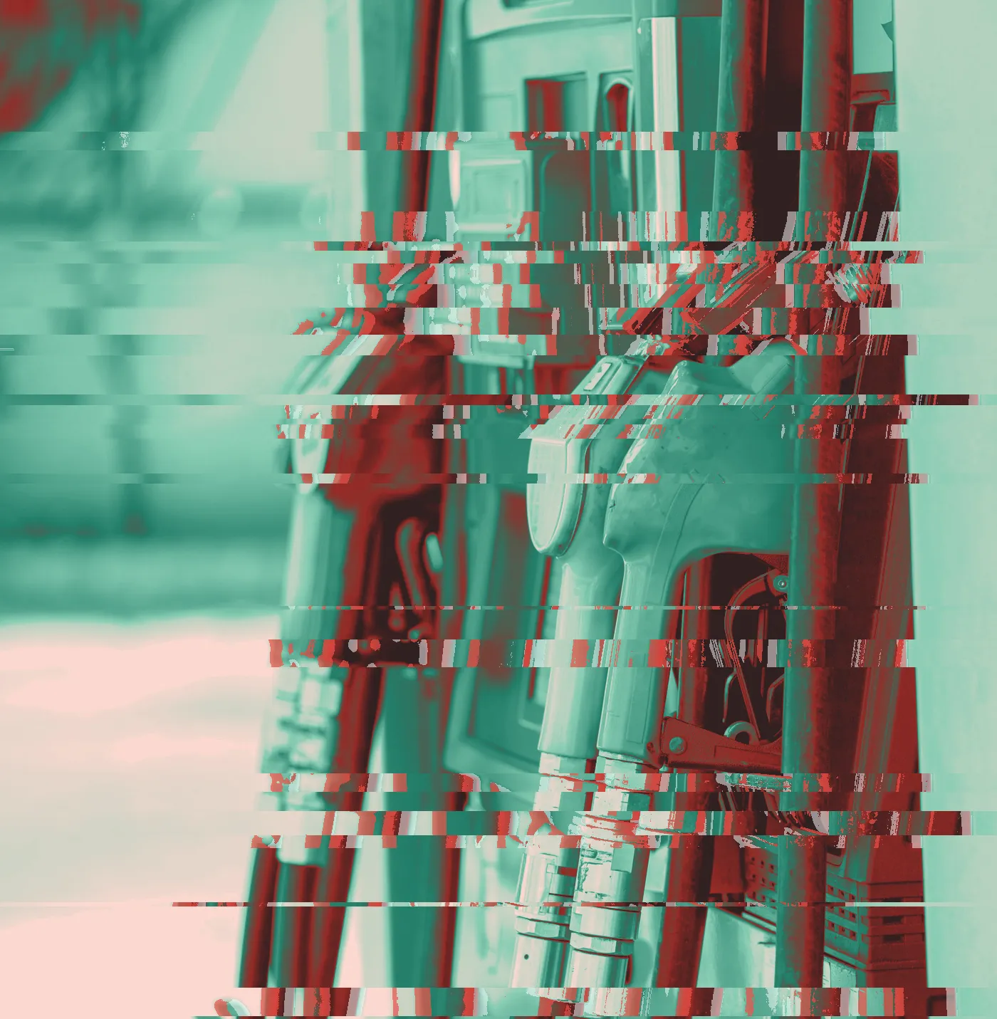 Orange, green and blue fuel nozzles hanging in pumps at a petrol station