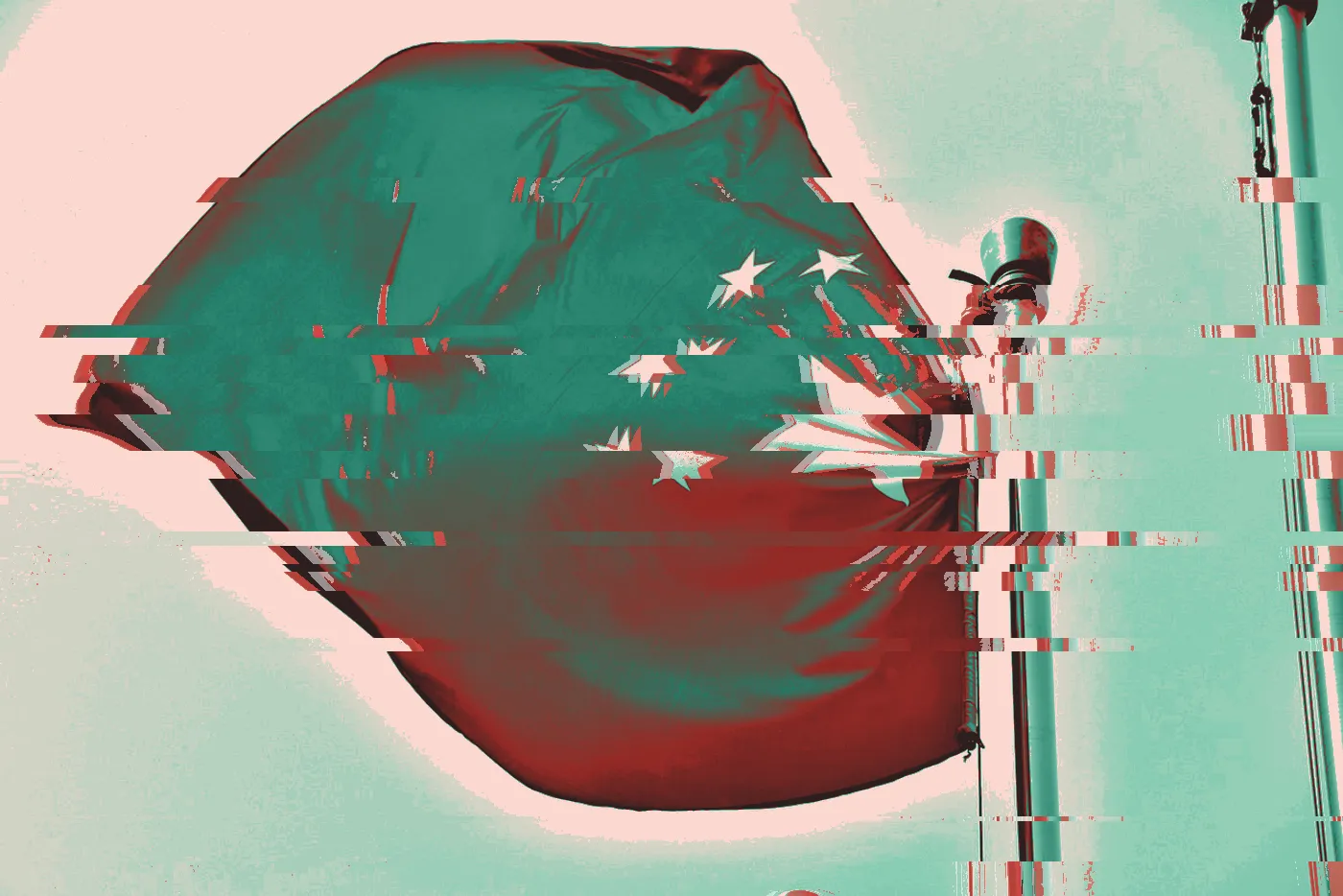 Chinese flag flying from a flagpole against a pale blue sky