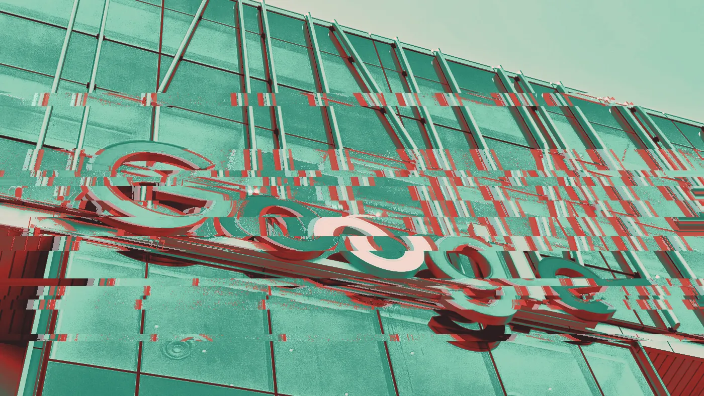 Colourful Google logo sign on a glass office building under a blue sky