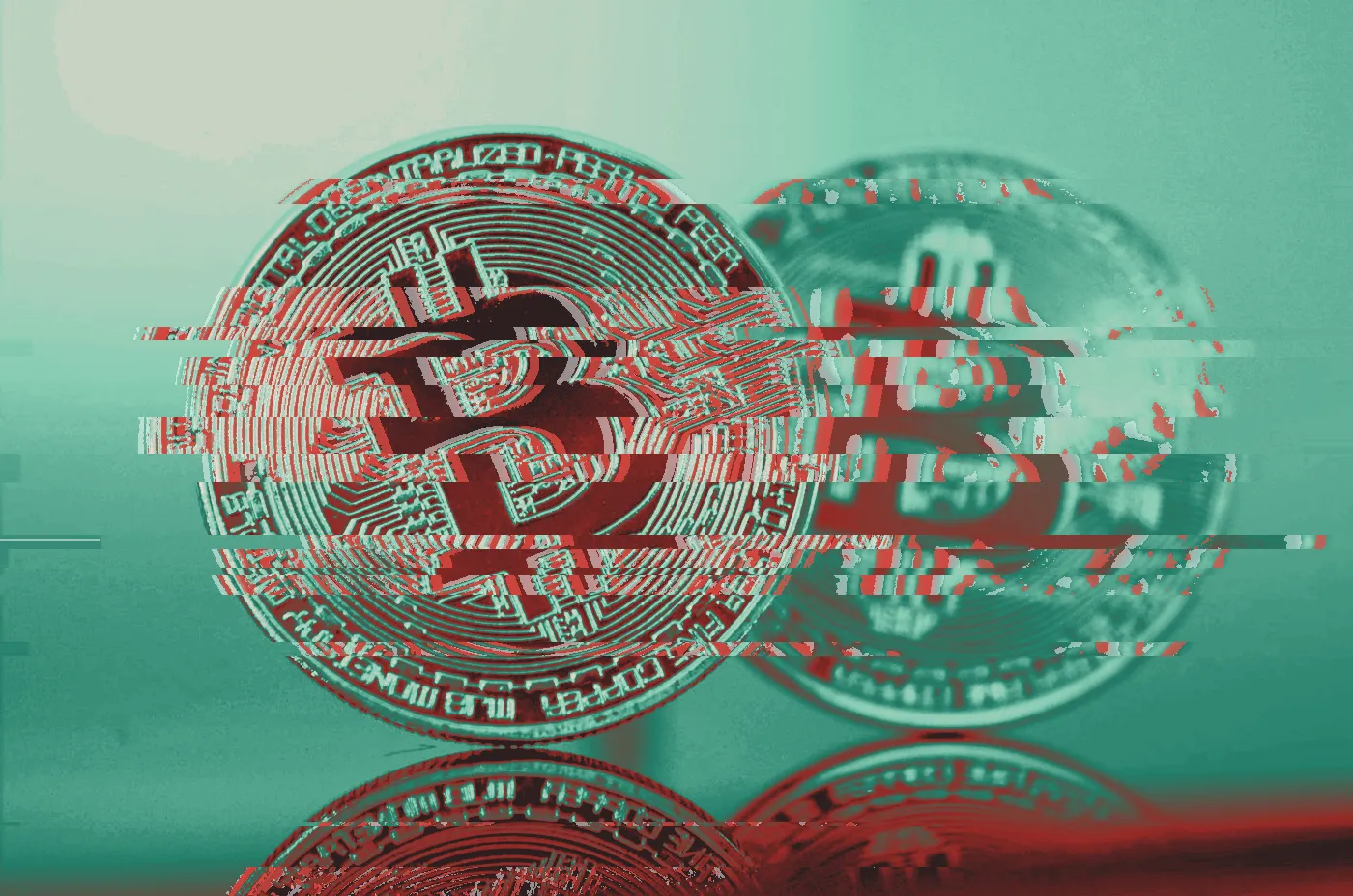Gold Bitcoin coin standing upright on a reflective surface with a second coin behind