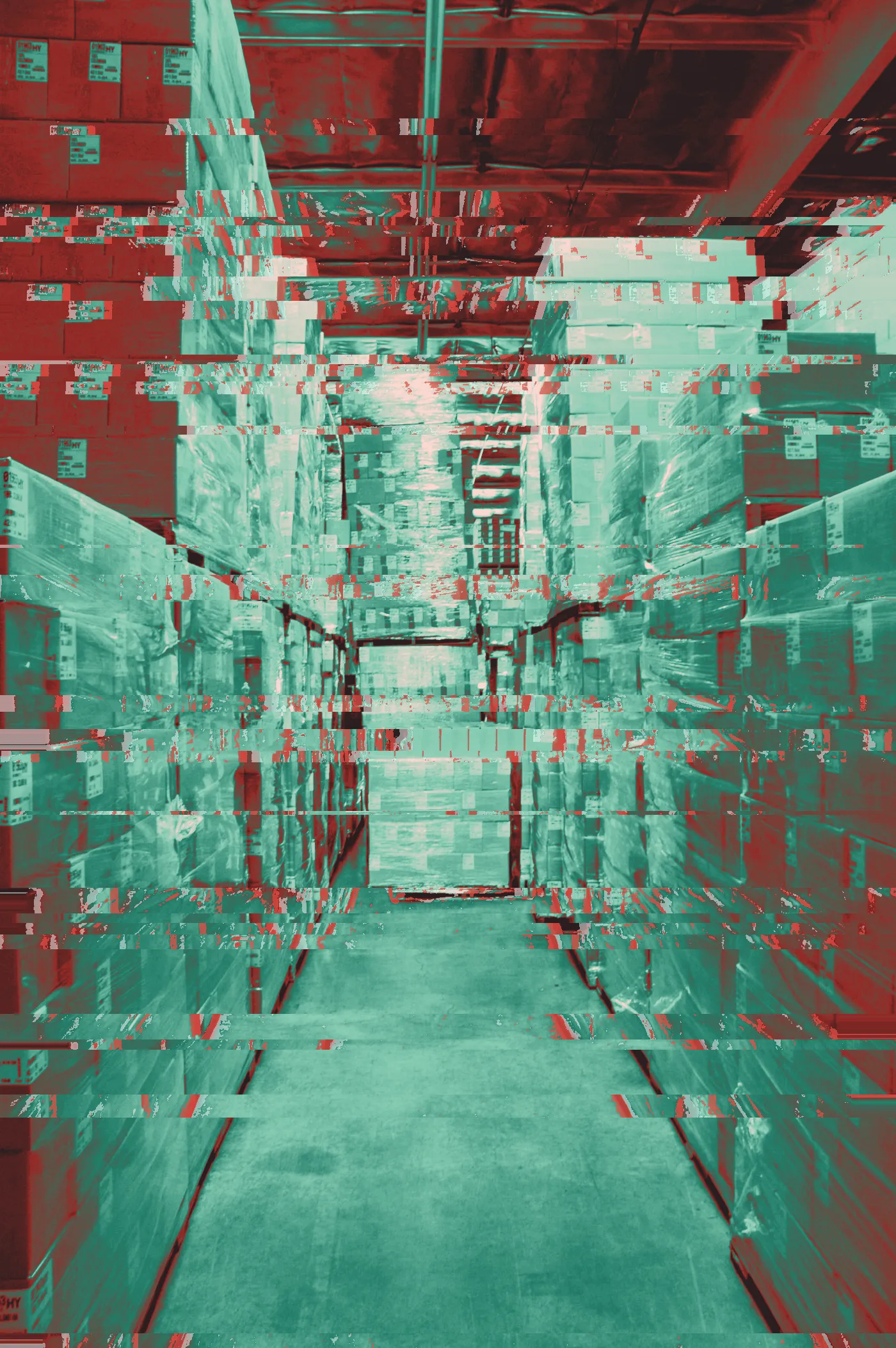 Warehouse aisle between tall stacks of shrink-wrapped cardboard boxes